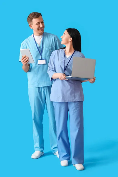 带有蓝底笔记本电脑和平板电脑的医疗助理 — 图库照片