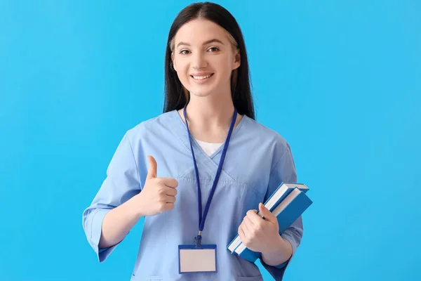 Female Medical Assistant Books Showing Thumb Blue Background — Stock Photo, Image