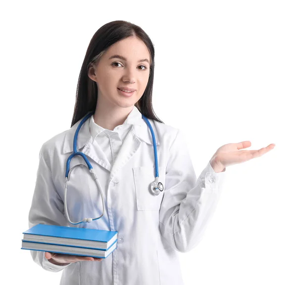 Vrouwelijke Medische Assistent Met Boeken Tonen Iets Witte Achtergrond — Stockfoto
