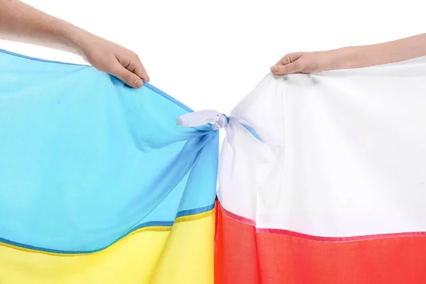 Volunteers with flags of Ukraine and Poland on white background