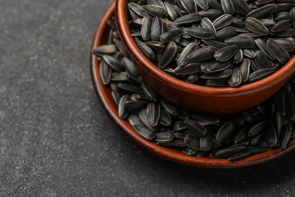 Koyu arkaplanda siyah ayçiçeği tohumları, yakın plan.