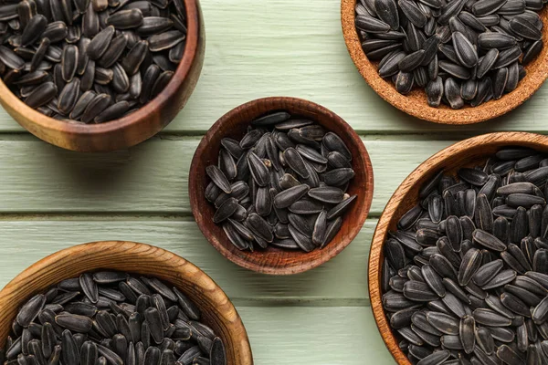 Yeşil ahşap arka planda siyah ayçiçeği tohumları