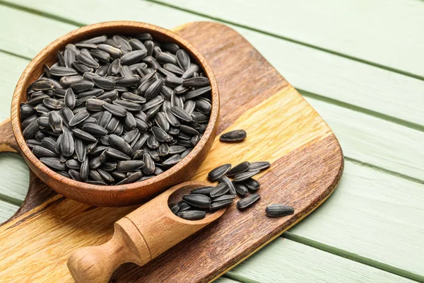 Yeşil arka planda kase, kepçe ve ayçekirdeği olan tahta