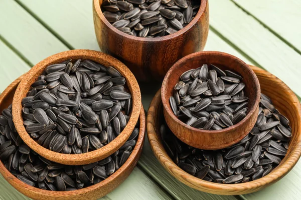 Yeşil ahşap arka planda siyah ayçiçeği tohumları