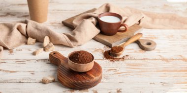 Kahve tozu ve süt ahşap masada.