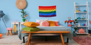 Ahşap banklı ve gökkuşağı bayraklı modern yatak odasının içi