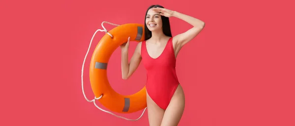 Female Beach Rescuer Holding Lifebuoy Red Background — Stock Photo, Image