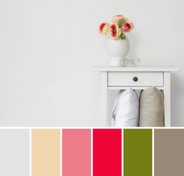 Işık duvarının yanındaki masada çiçekli vazo. Farklı renk desenleri 