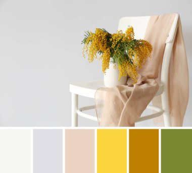 Bir buket mimoza çiçekli vazo ve arka planda hafif bir sandalye. Farklı renk desenleri