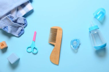 Mavi arka planda erkek bebek için kıyafetler ve farklı aksesuarlar.