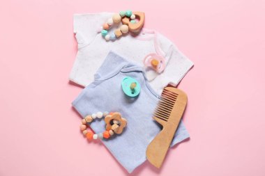 Pembe arka planda bebek kıyafetleri ve aksesuarlar