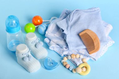 Mavi arka plandaki erkek bebek için hoş kıyafetler ve farklı aksesuarlar.