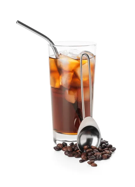 Glass of cold brew, coffee beans and spoon on white background