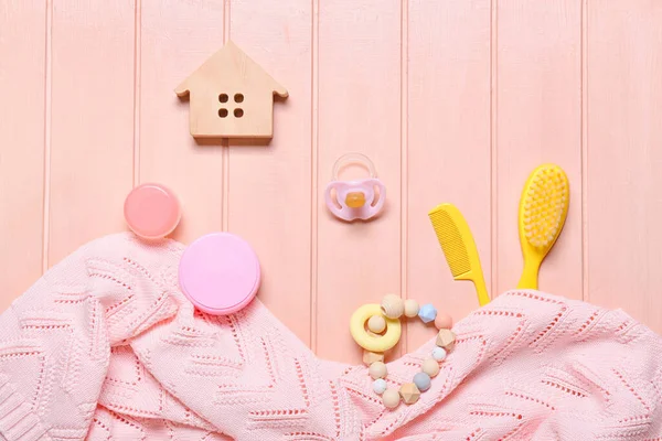 粉红木制背景的婴儿用品和针织毛衣 — 图库照片