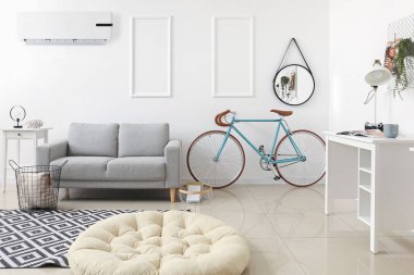 Kanepesi, bisikleti ve kliması olan modern bir oturma odası.