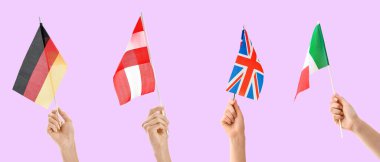 Leylak arka planında farklı ülkelerin bayrakları olan eller