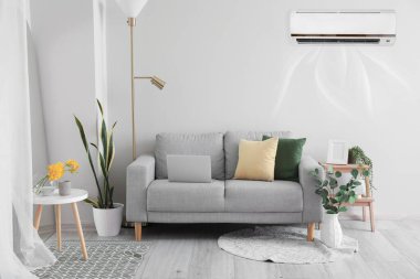 Şık bir kanepe ve klimalı bir aydınlık odada.