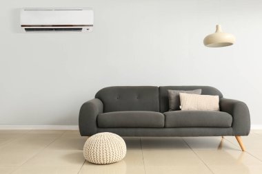 Şık bir kanepe ve klimalı bir pouf.