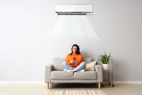 Hermosa Mujer Joven Con Teléfono Móvil Descansando Sofá Sala Luz — Foto de Stock