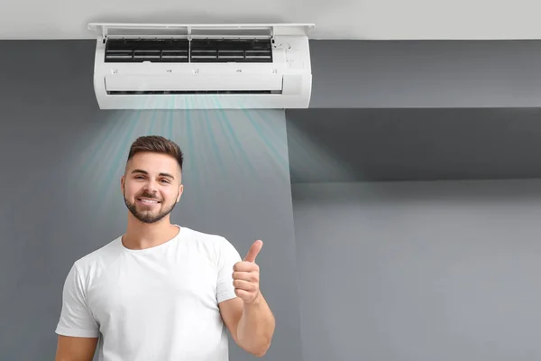 Happy Young Man Showing Thumb Room Operating Air Conditioner — Stock Photo, Image