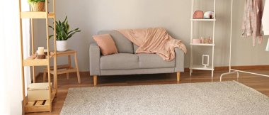 Rahat kanepe ve raf üniteleriyle aydınlık oturma odasının içinde.