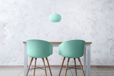 Yemek masası ve ışık duvarının yanındaki sandalyeler.