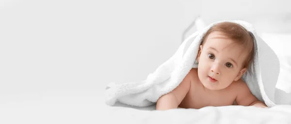 テキストのためのスペースと光の背景にタオルの下に愛らしい赤ちゃんの男の子の肖像画 — ストック写真