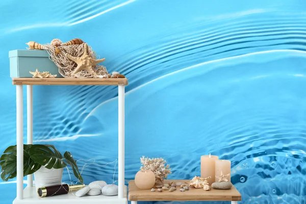 墙上有燃烧的蜡烛和海贝壳的贝壳 上面印着清澈的蓝色水 — 图库照片