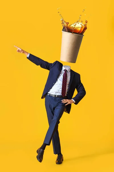 黄色の背景に彼の頭の代わりに熱いコーヒーのカップでビジネスマンを踊る — ストック写真