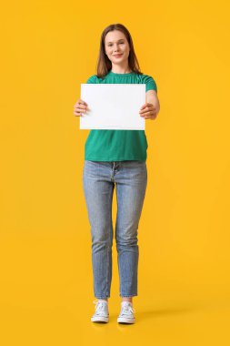 Sarı arka planda zarfı olan güzel genç bir kadın.