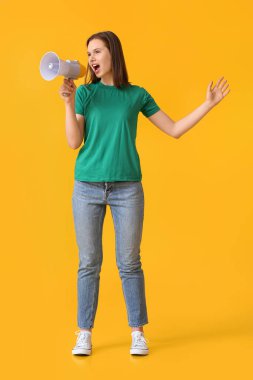 Sarı arka planda megafona bağıran güzel genç bir kadın.