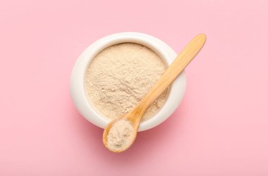 Pembe arka planda bir kase dolusu karabuğday unu.