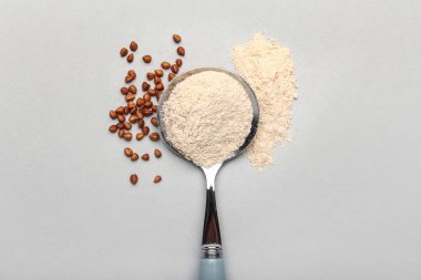 Hafif arkaplanda bir kaşık un ve karabuğday taneleri