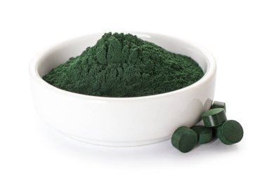Bir kase spirulina tozu ve beyaz arka planda haplar.