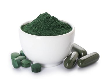Bir kase spirulina tozu ve beyaz arka planda haplar.