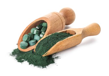 Sarmaşık tozlu ahşap kepçeler ve beyaz arka planda haplar.