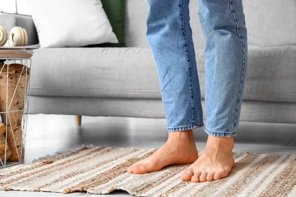 Young barefoot man at home, closeup