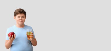 Hafif arka planda elma ve meyve suyu olan kilolu çocuk, metin için yeri var.