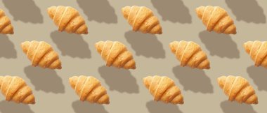 Gri arka planda bir sürü taze kruvasan var. Tasarım için desen