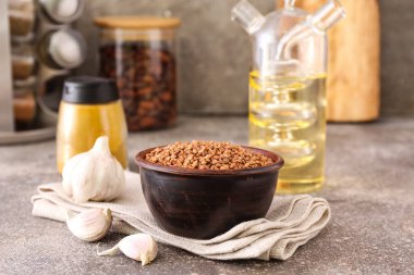 Karabuğday taneli kase ve grunge masasında taze sarımsak.