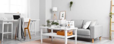 Sehpası, kanepesi ve işyeri olan aydınlık oturma odasının içinde.