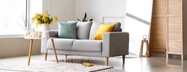 Kanepesi, masası, aynası ve katlanır perdesi olan modern oturma odasının içinde.