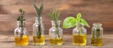 Ahşap arka planda farklı temel yağlardan şişeler