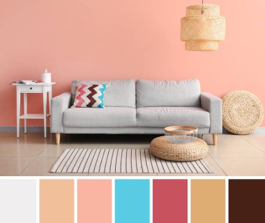 Rahat bir kanepe ve oturma odasındaki pembe duvarın yanındaki masa. Farklı renk desenleri