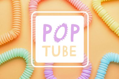Turuncu arka planda farklı renkli pop tüpleri