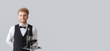 Açık arkaplanda kırmızı şarap ve metin için yeri olan yakışıklı garson