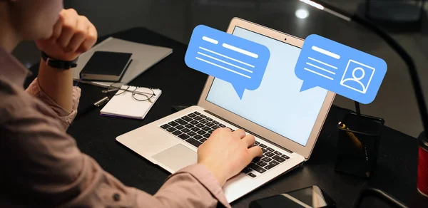 Young businessman with laptop chatting online in office