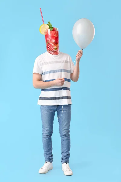 Man with balloon and watermelon cocktail instead of his head on light blue background