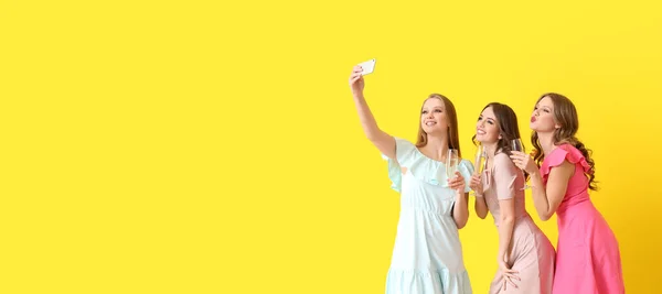 Jovens Mulheres Bonitas Com Copos Champanhe Tomando Selfie Fundo Amarelo — Fotografia de Stock