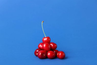 Mavi arka planda bir yığın tatlı kiraz